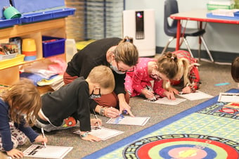 PreK teacher works along side students