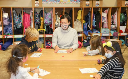 Students work in a small group with a teacher reading stories highlighting sight words