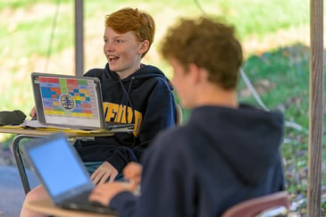 Two Upper School students engage in conversation in an outdoor math class