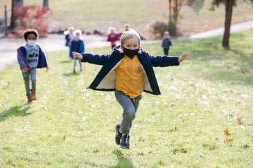 PreK student frolics outdoors