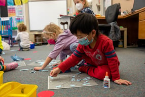 Preschool student designing a snowflake in world language class